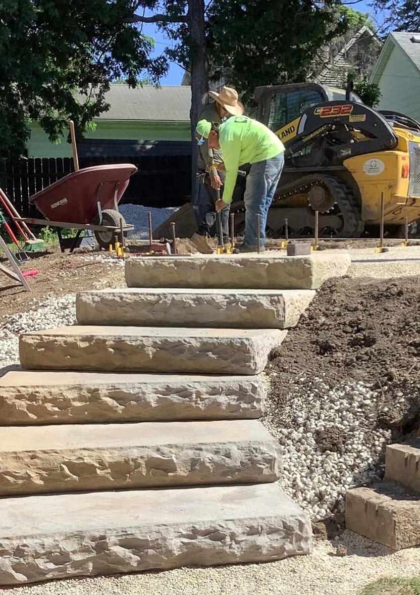 Landscapers installing stone steps.