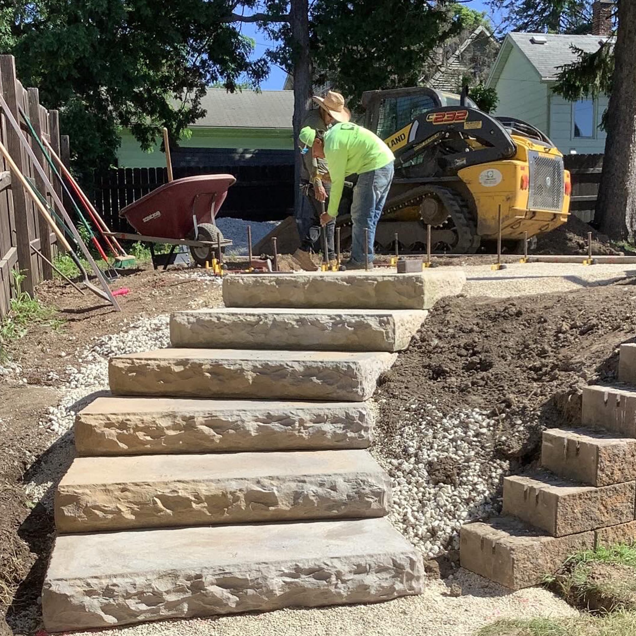 Landscapers installing stone steps.